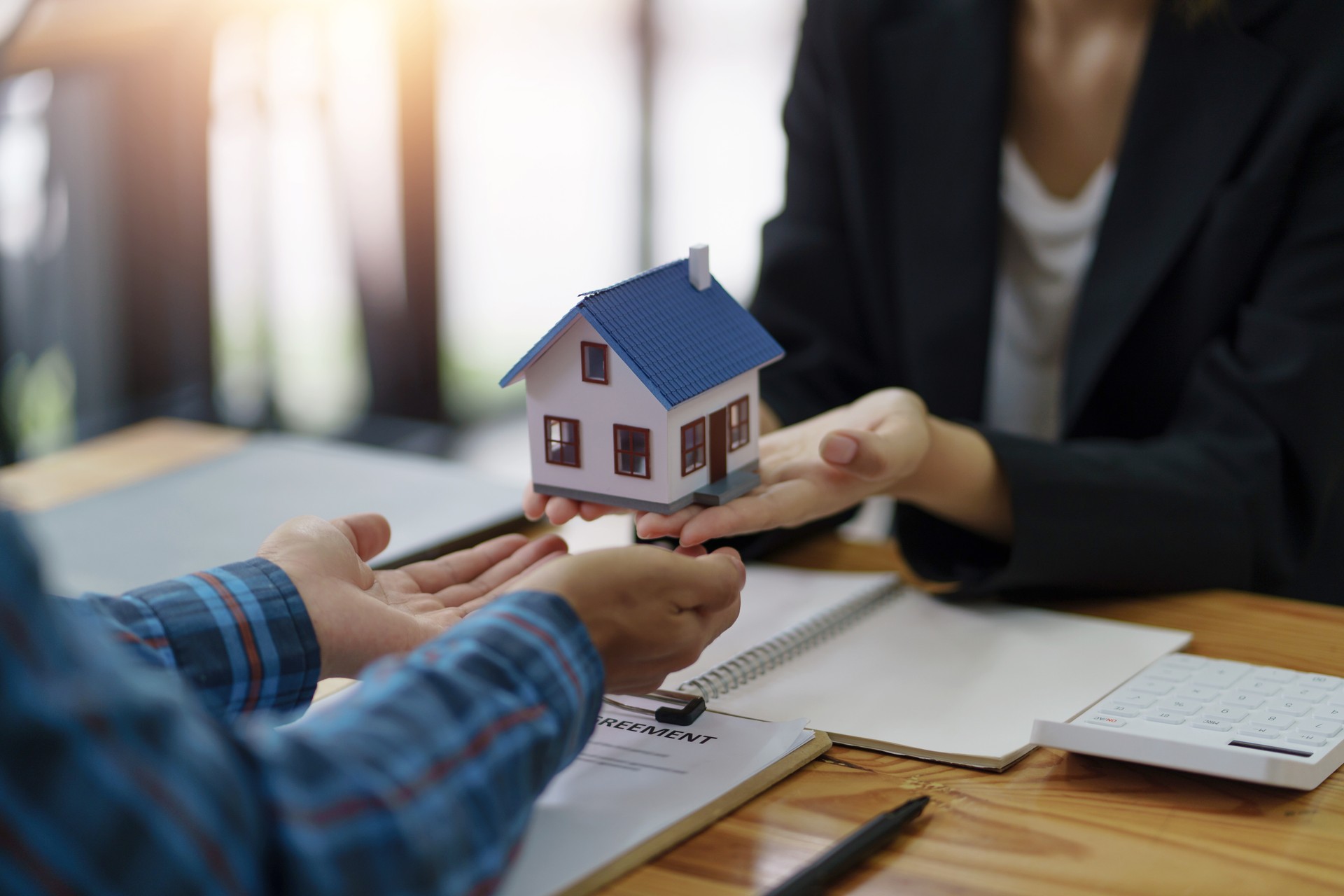 The real estate agent is explaining the home design to interested clients and signing an office sales contract.