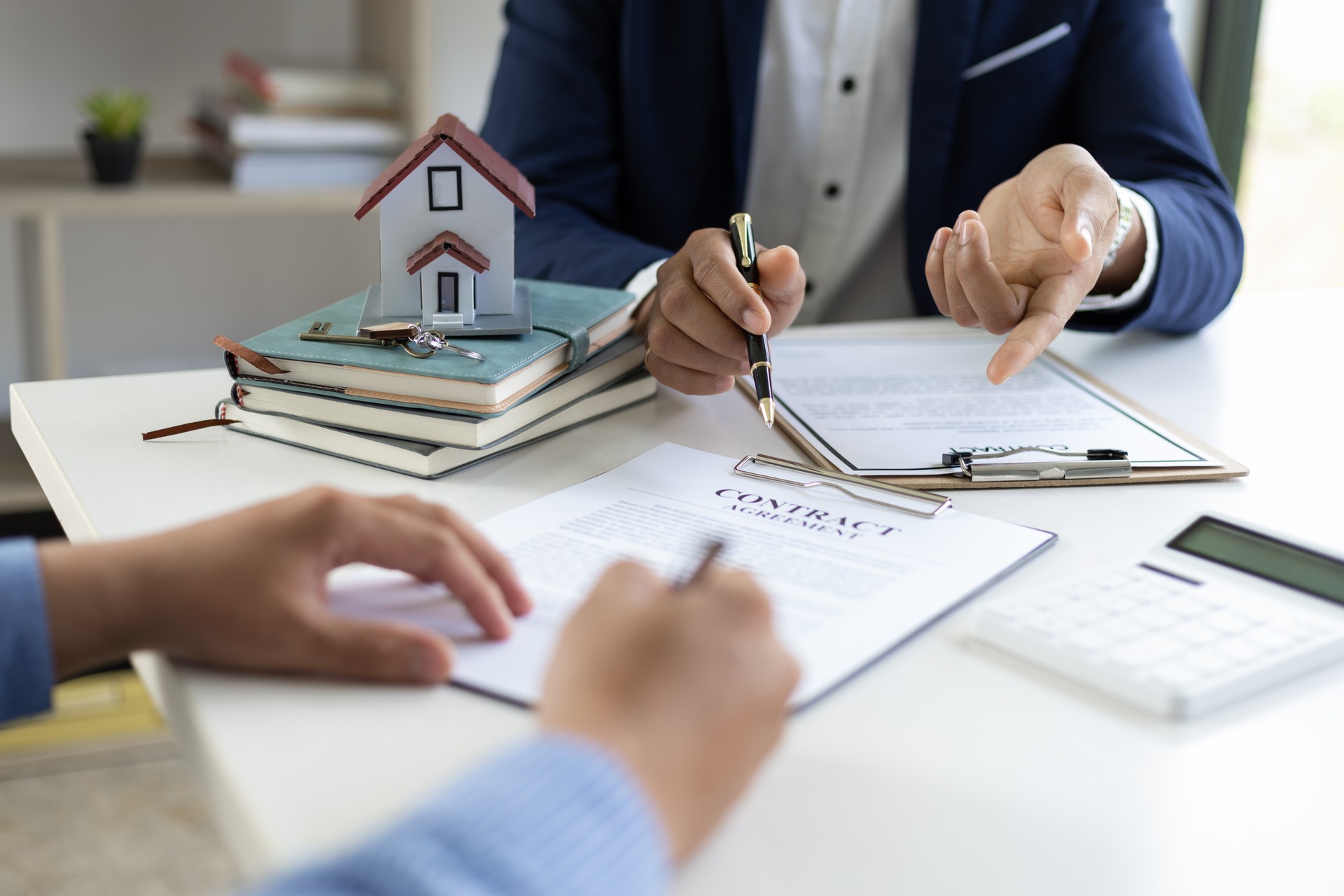 The real estate agent explaining the terms in the legal real estate agreement contract document, waiting for customer to sign. Mortgage, Lease, Home Insurance Concepts